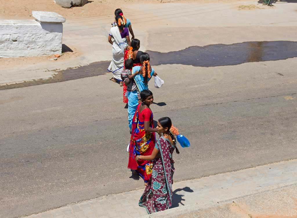 A group of ladies crossing the road in single-file on top of Chamundi Hills in India