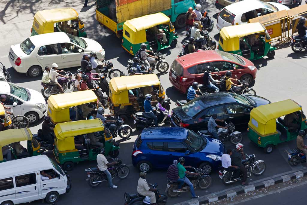 Traffic at the junction of Mahatma Gandhi Road, Old Madras Road and Trinity Road in Bangalore, India, tut-tuts, motorbikes and cars gridlocked