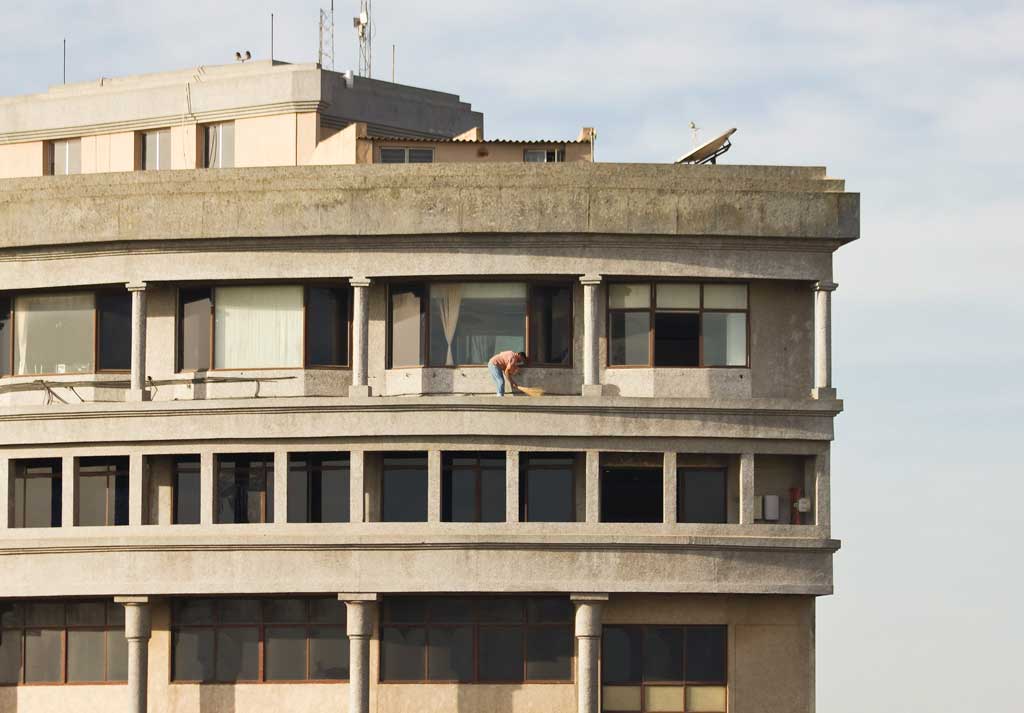 Sweeping the ledge of an apartment eight stories up in Bangalore, India
