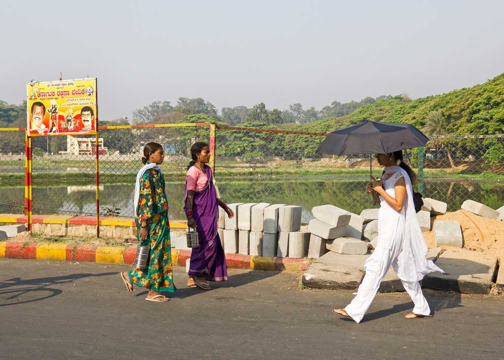 Ladies walking in the midday sun past Ulsoor lake in Bangalore, India