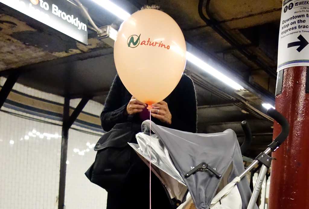 Street - woman and balloon in the New York subway